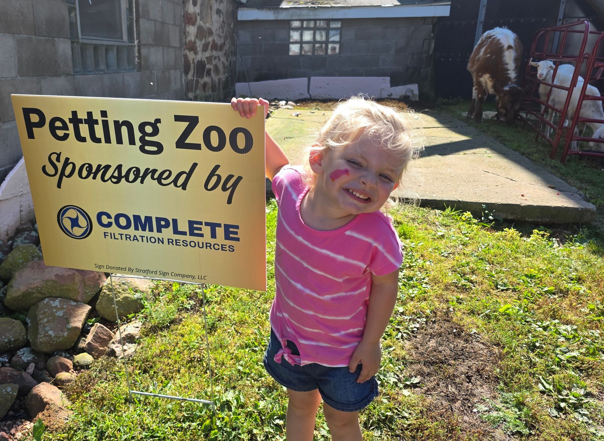 Young child smiles, holding a 
