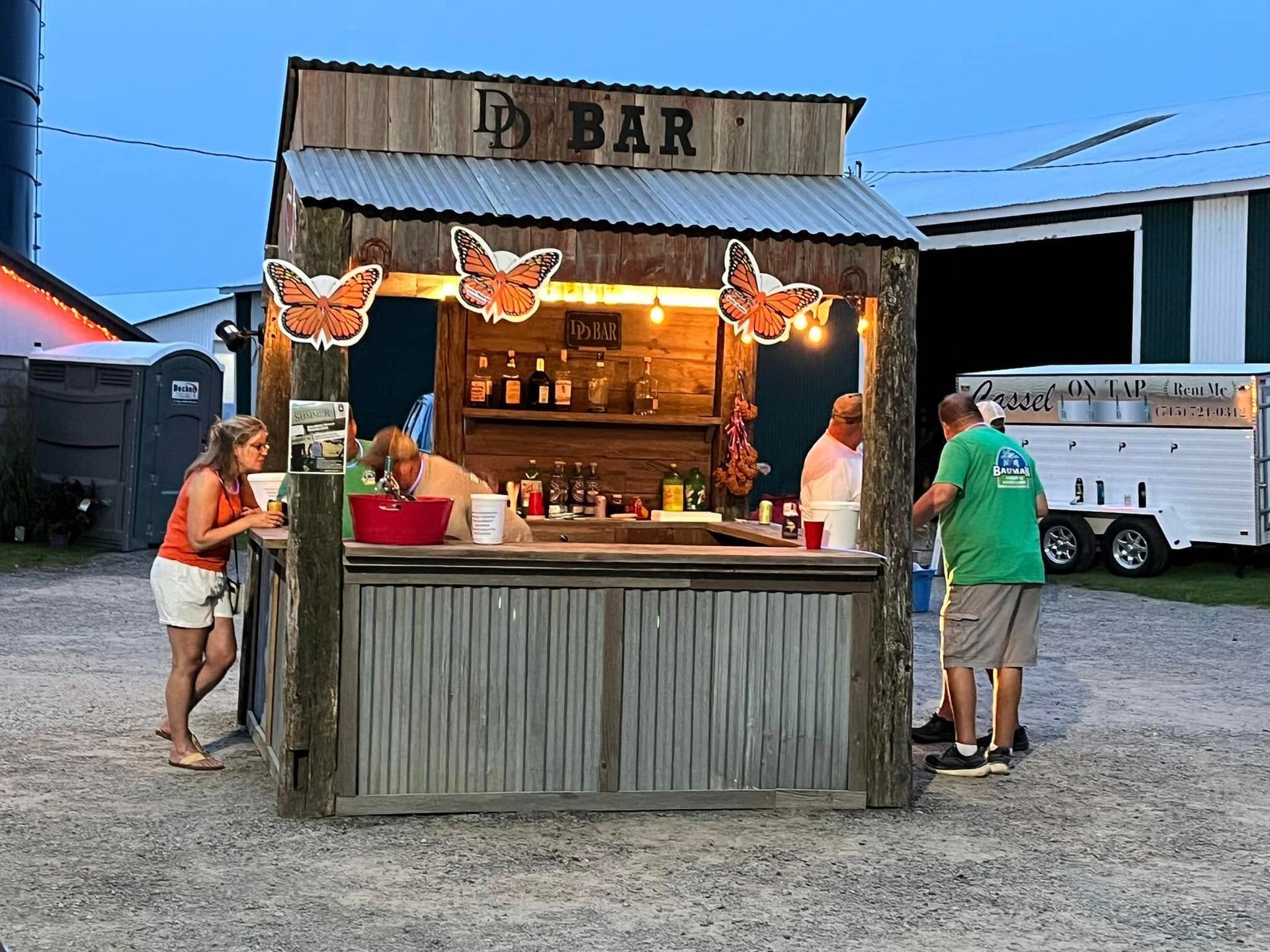 A group of people are standing around a wooden bar.