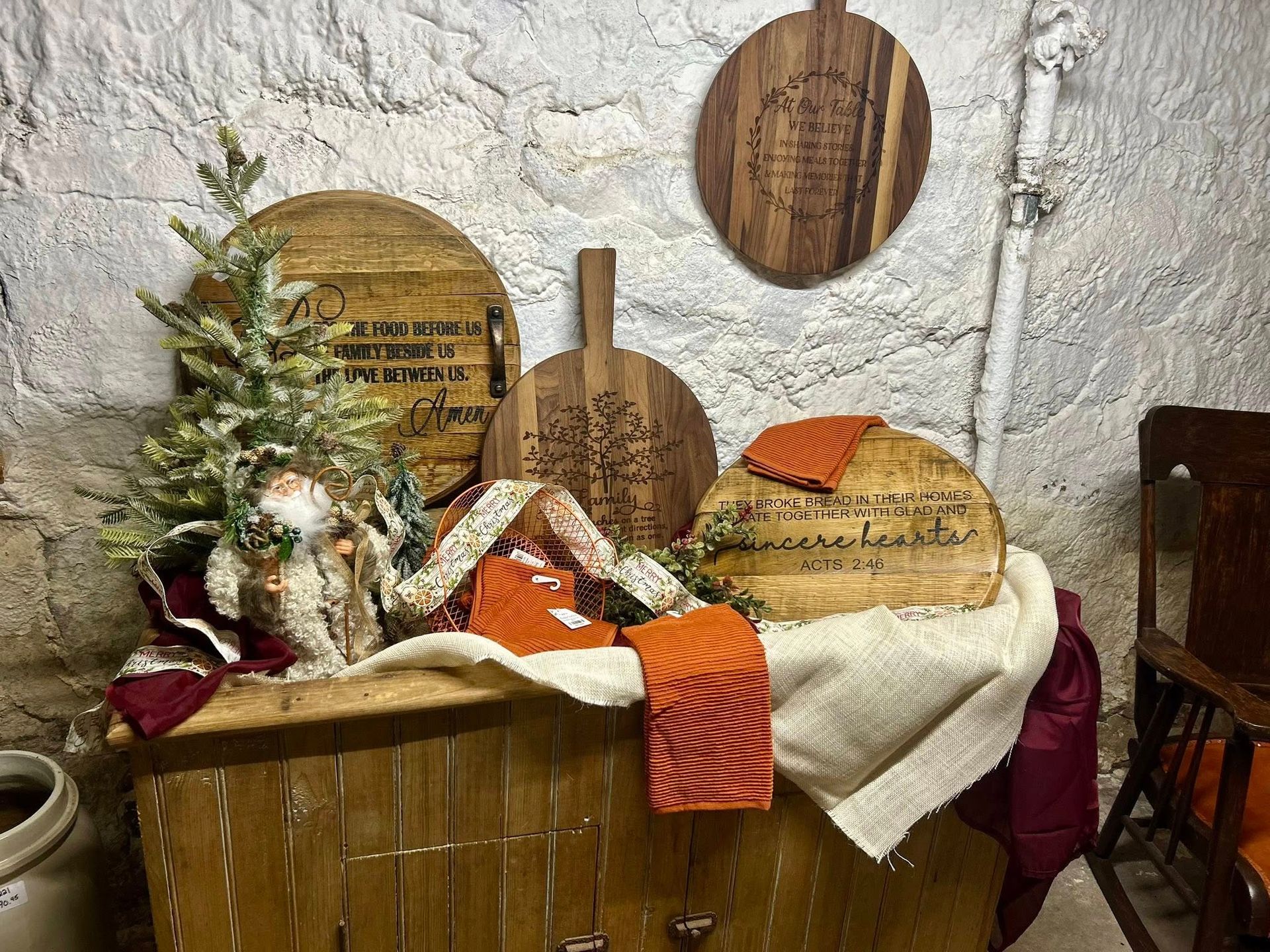 Wooden boards and Christmas decor on a chest in a stone-walled room.