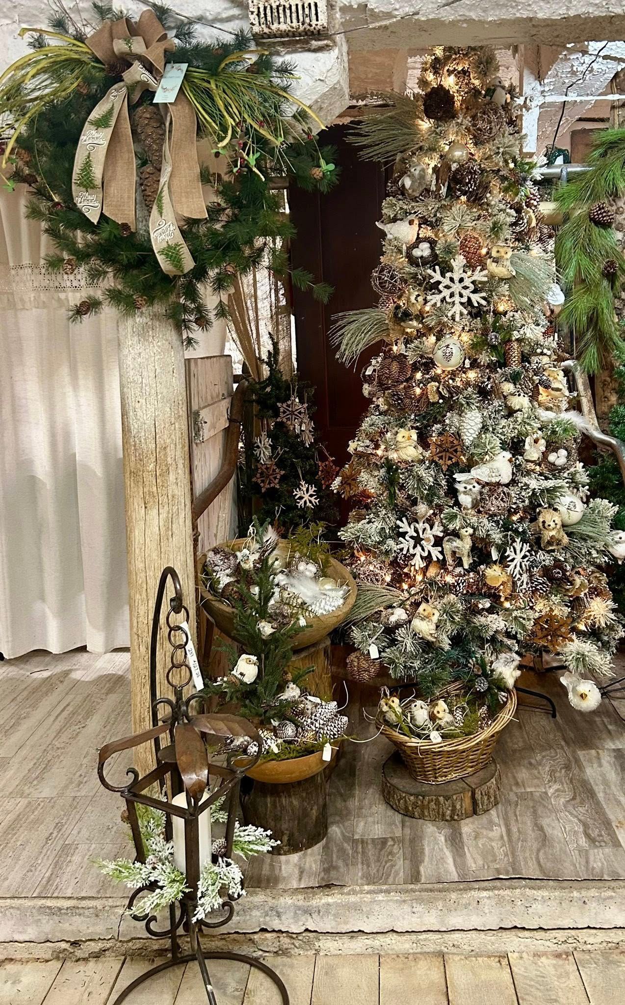 Christmas decorations: wreath, frosted tree, small plants in pots, lantern.