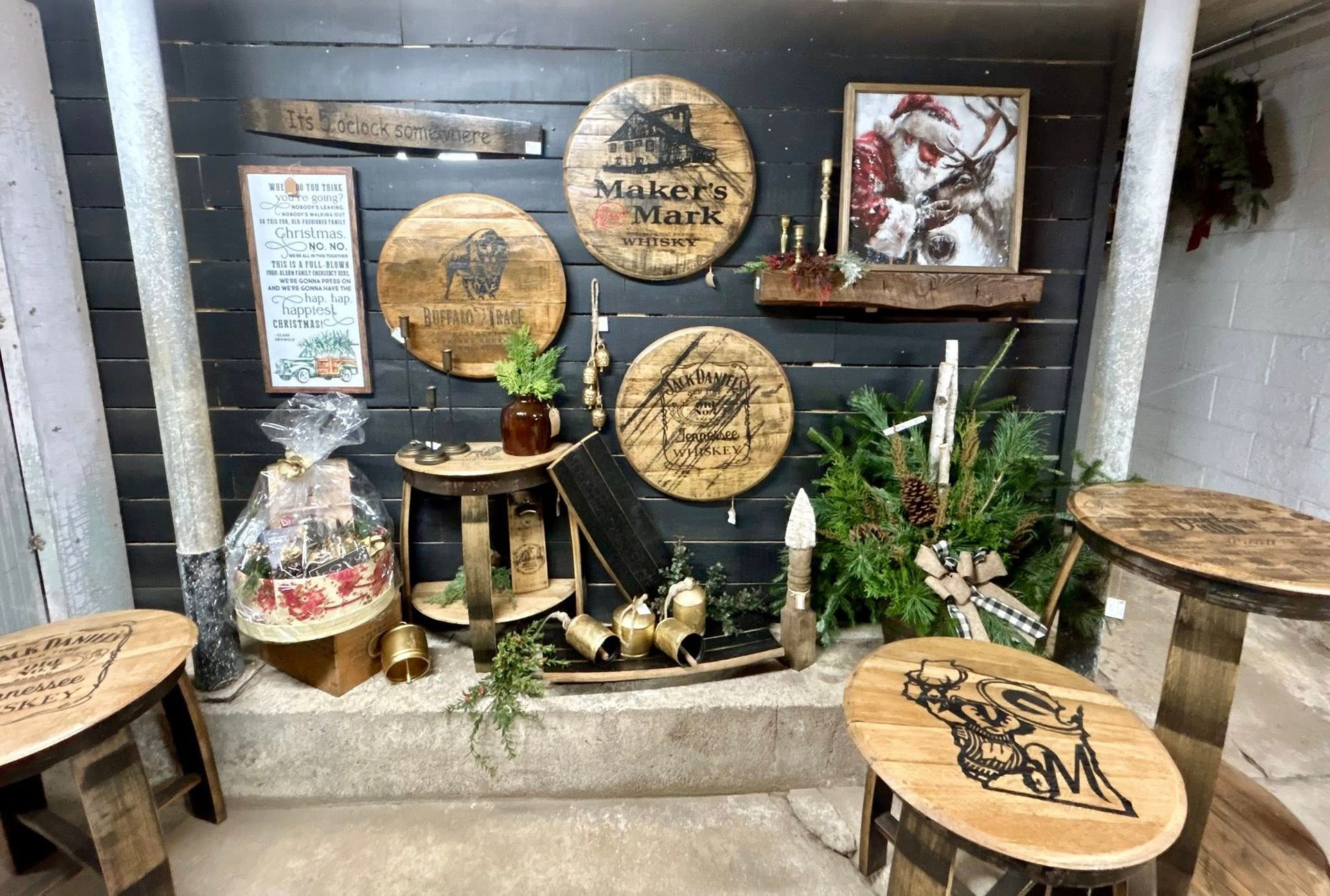 Display of handcrafted wooden items, including barrel tops with logos and small stools, in a shop setting.