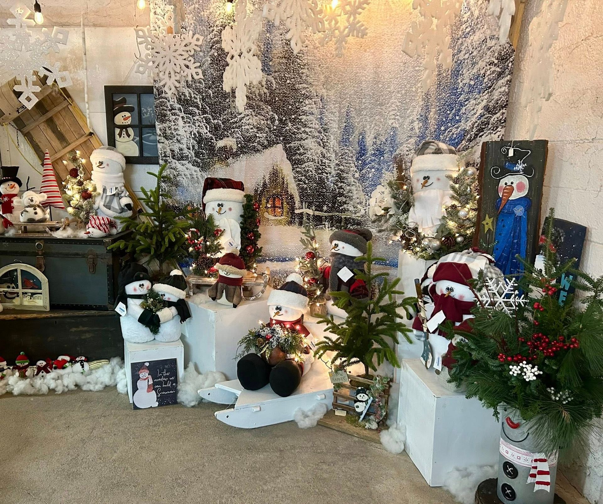 A Christmas-themed display with snowman decorations and snowy backdrop.