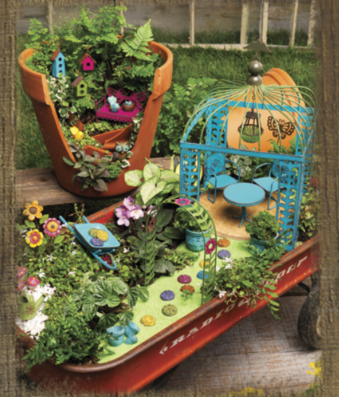 Miniature garden scene with broken pot and red wagon; blue gazebo, colorful flowers, and tiny figures.