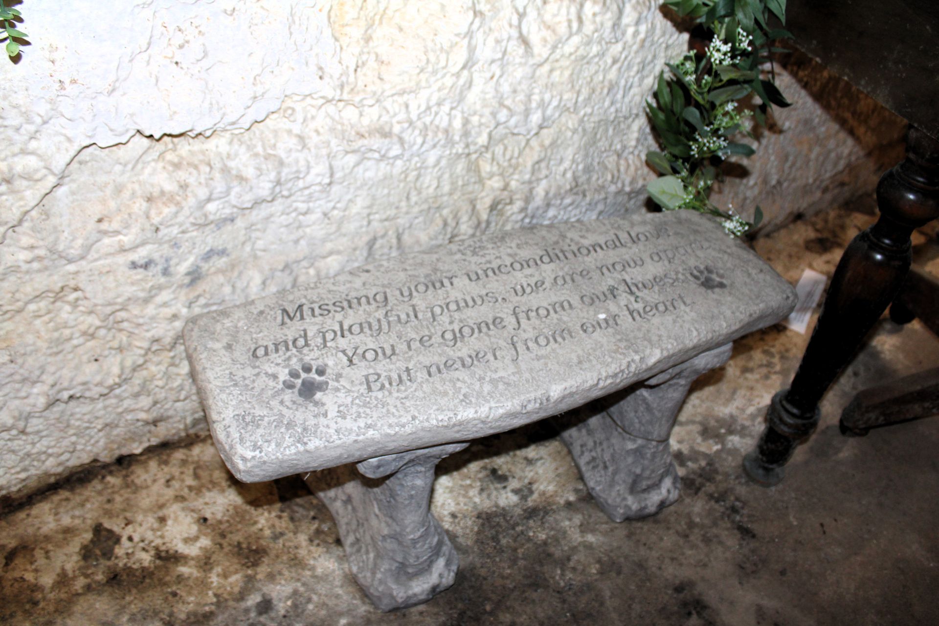 Stone bench with paw prints and inscription: 