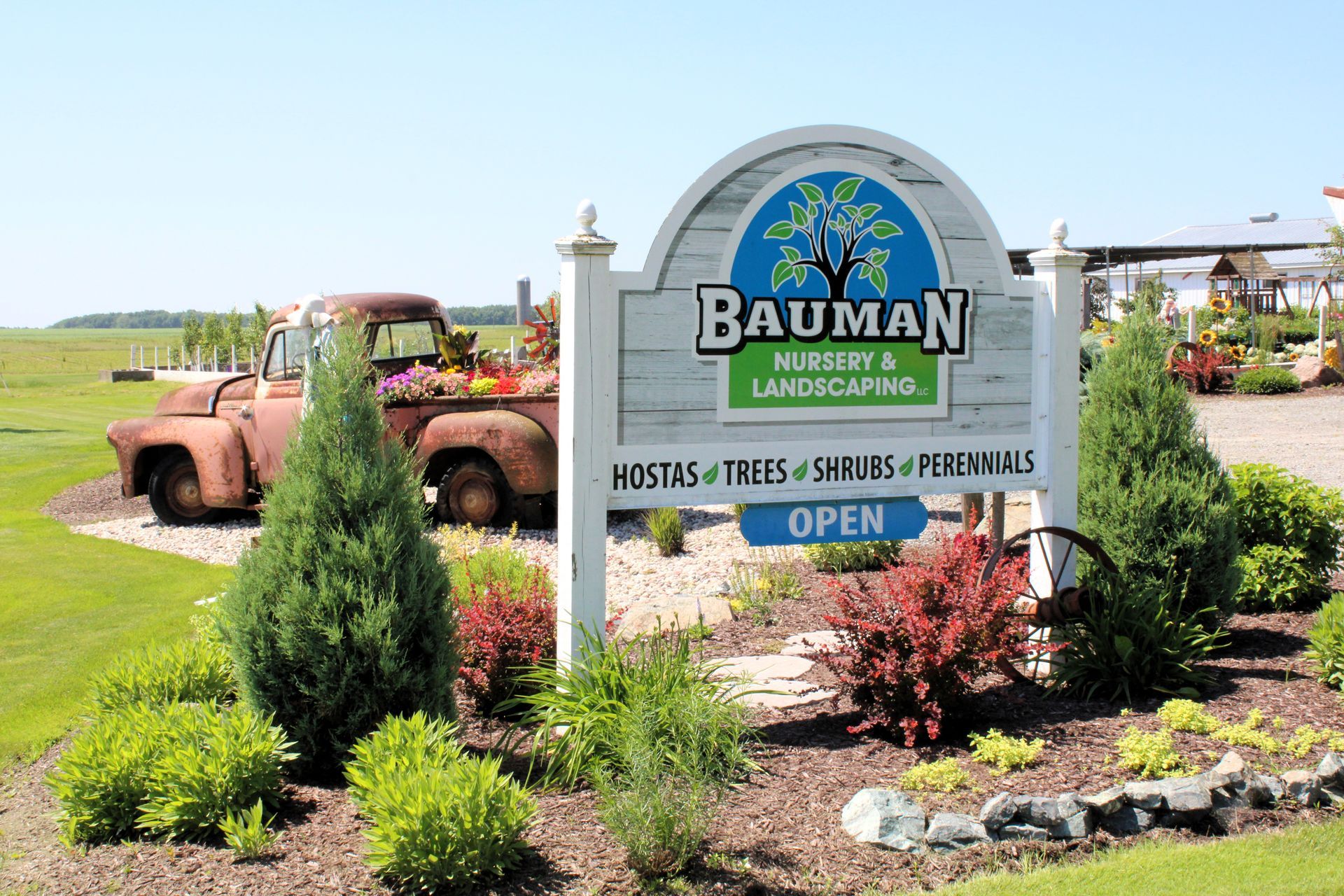 A white sign with pumpkins and a plow in front of it.