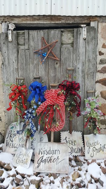 Wooden door decorated with bows and signs; snow on the ground. A star hangs above.