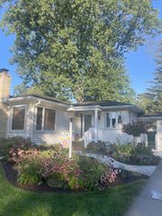 A field of pink and orange flowers surrounded by green leaves.