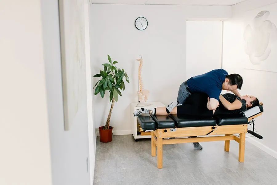 chiropractor Thang Tran DC is stretching a woman 's back on an adjustment table.