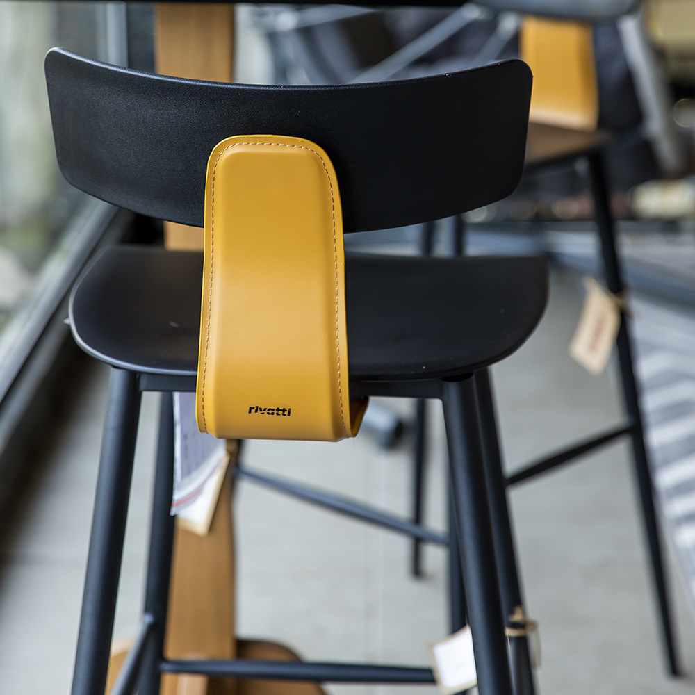 Um banco de bar preto com assento e encosto amarelos