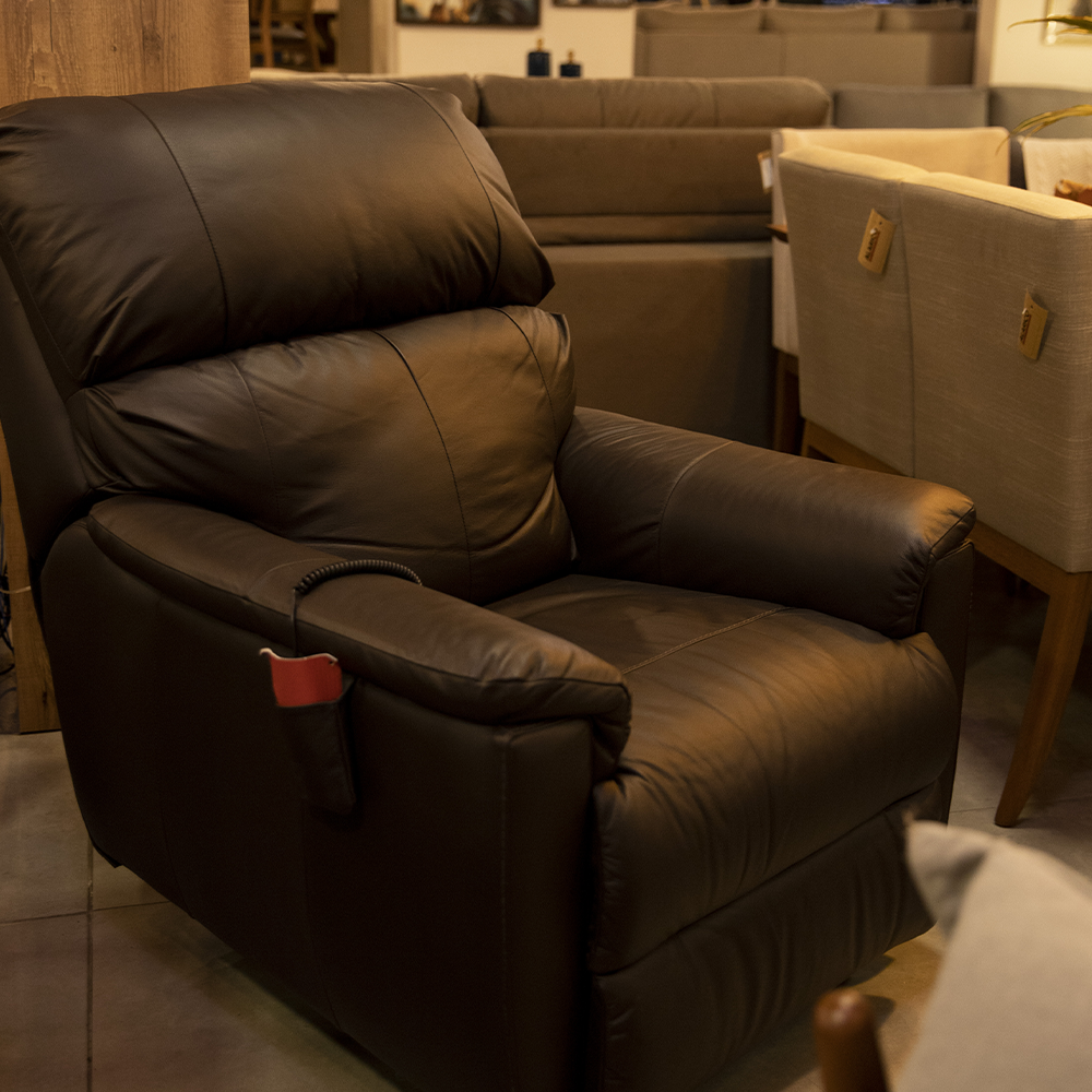 Uma poltrona reclinável de couro preto com uma etiqueta vermelha no apoio de braço