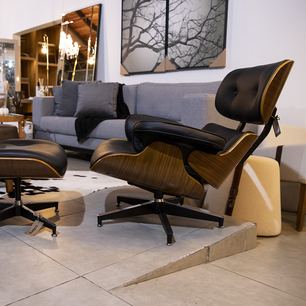 Uma sala de estar com cadeira e pufe e sofá