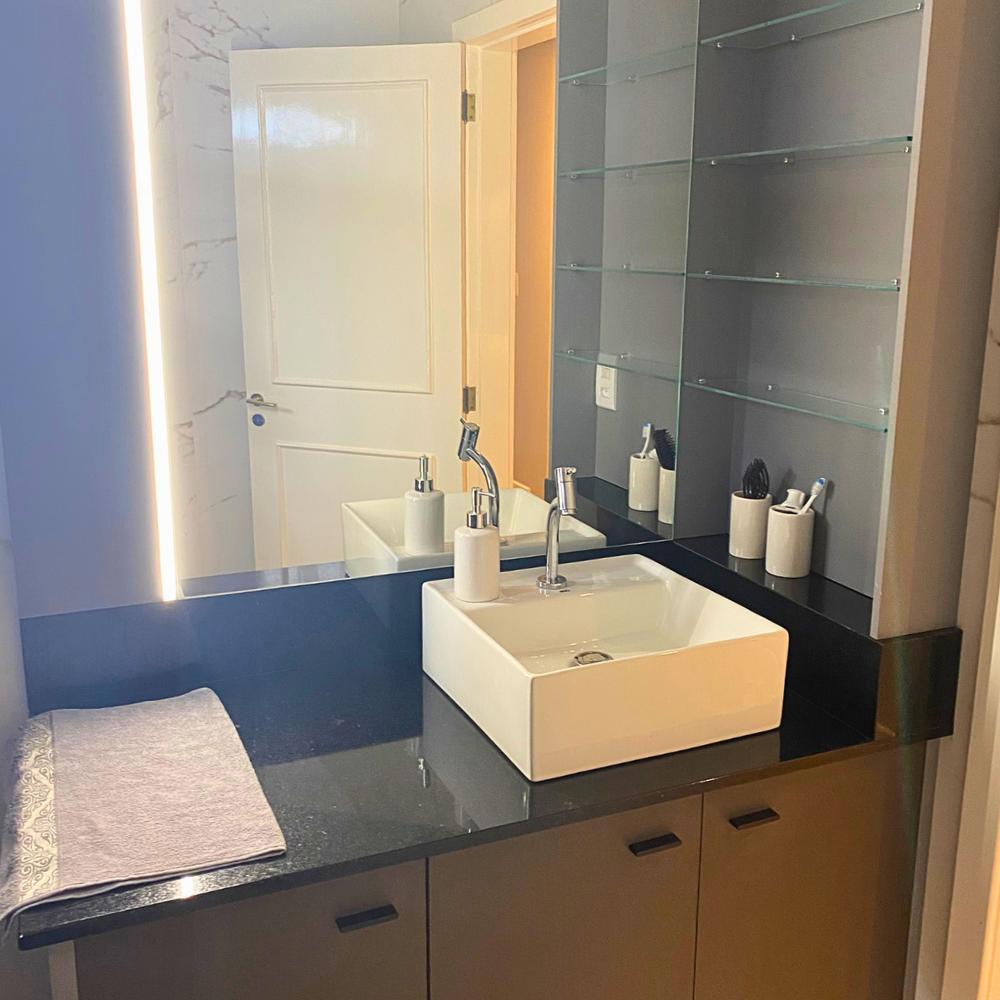 Um banheiro com vaso sanitário, pia e um quadro na parede