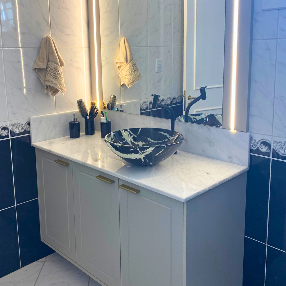 Um banheiro com vaso sanitário, pia, espelho e chuveiro.