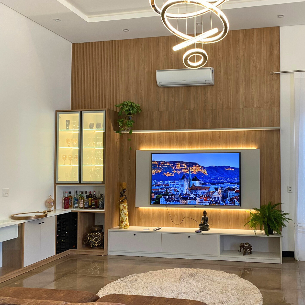 Uma sala de estar com TV de tela plana montada na parede.