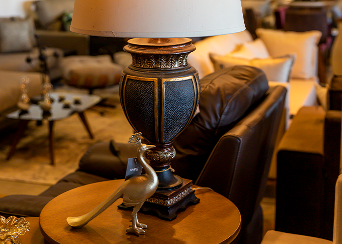 Uma lâmpada está em cima de uma mesa de madeira em uma sala de estar.