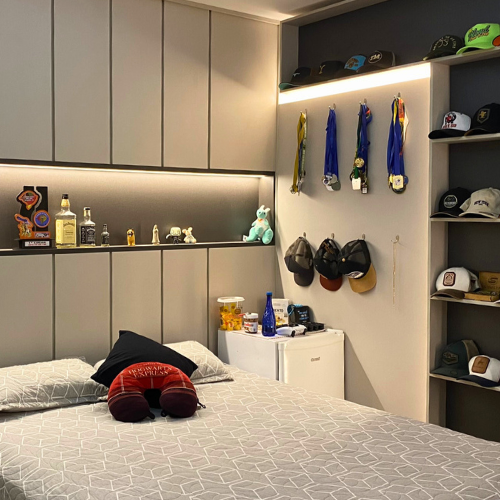 Um quarto com cama, mesa de cabeceira, pufes e guarda-roupa.