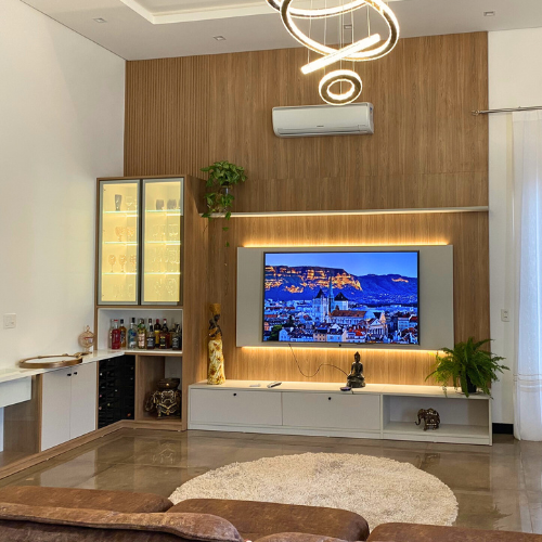 Uma sala com sofá, cadeiras, mesa e televisão.