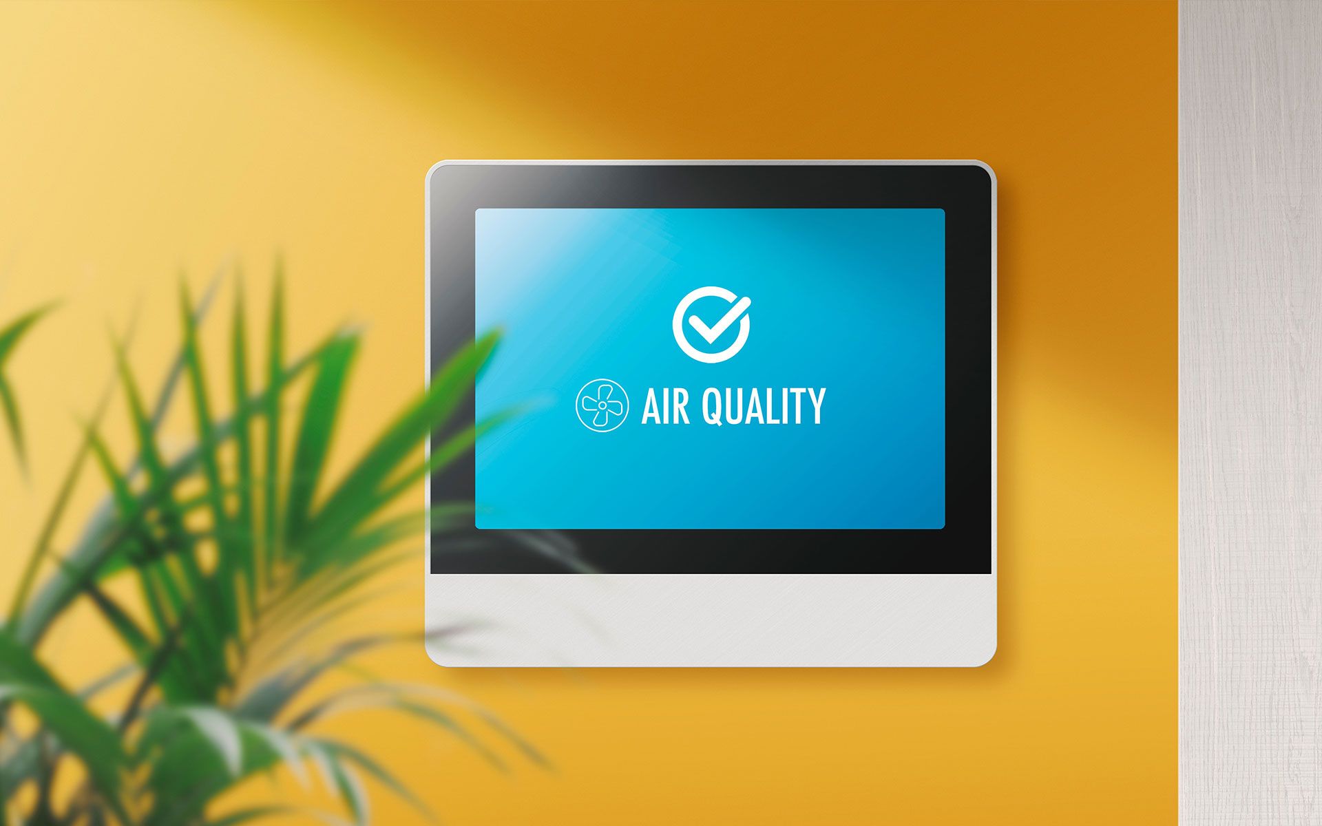 Air quality monitor on a yellow wall with a checkmark logo indicating good air quality.