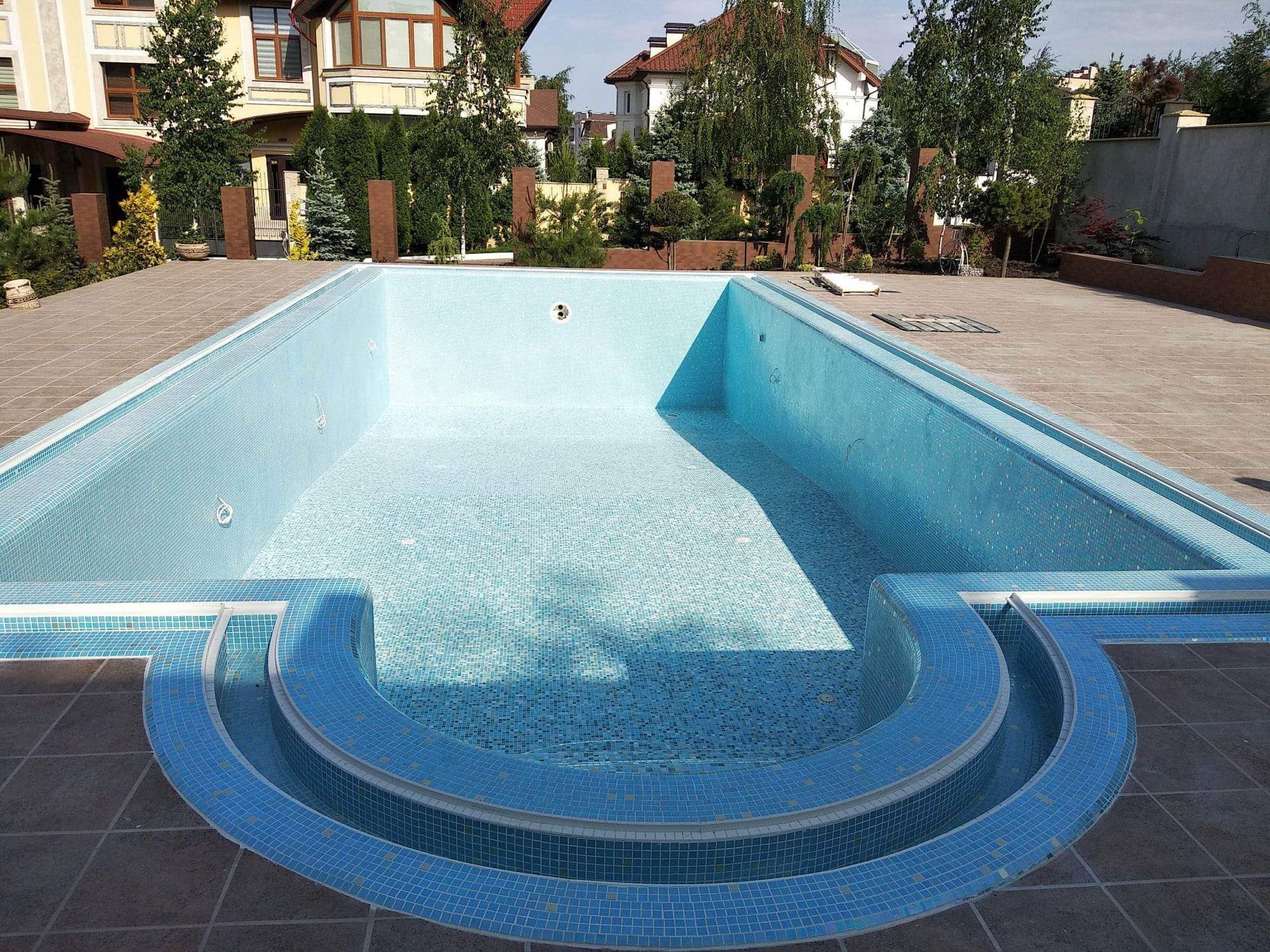 A freshly tiled swimming pool with blue tiles completed by Master Tiling.