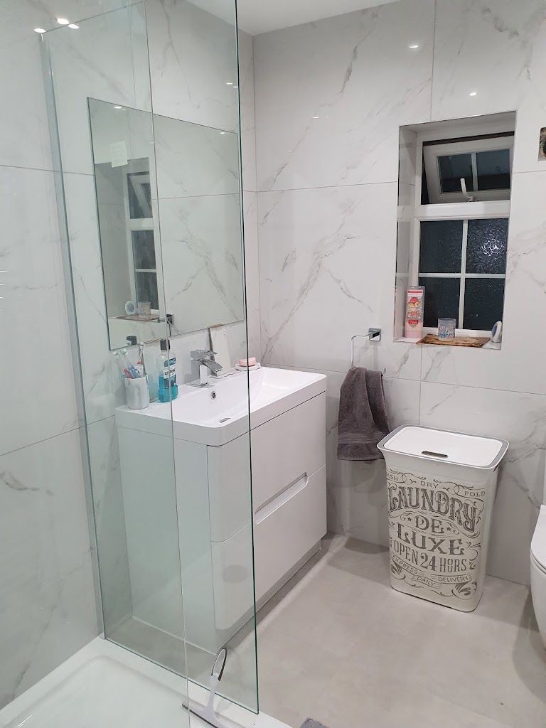 A lovely bathroom, renovated in London by Master tiling with soft white and grey marble tiles.