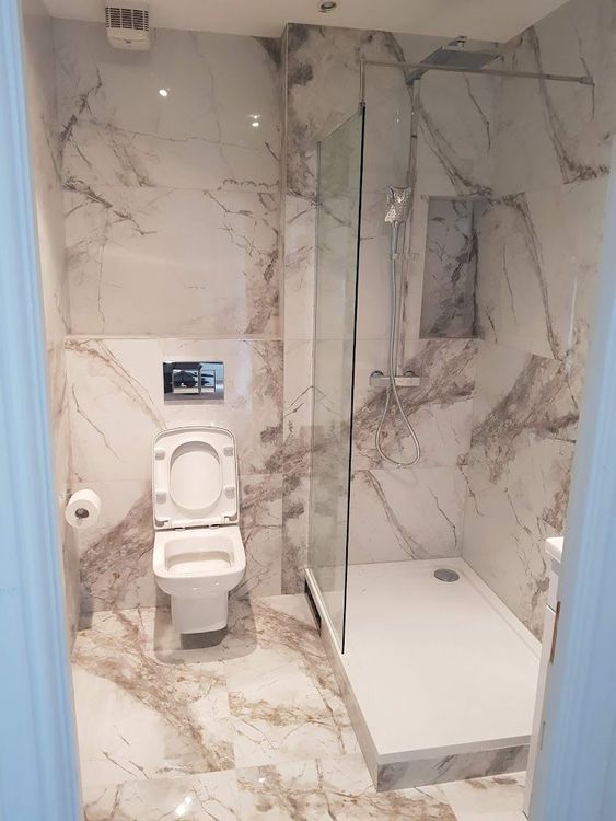 A pristine white marble tiled bathroom, completed in London by Master Tiling