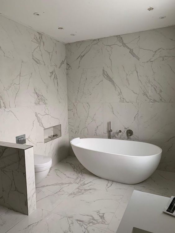 A pristine white marble tiled bathroom, completed in London by Master Tiling