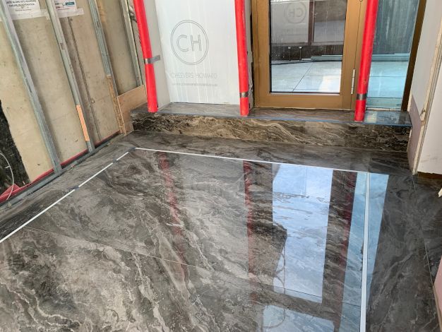 A marble grey shiny tiled floor in Holland apartments London. Expertly completed by Master Tiling.