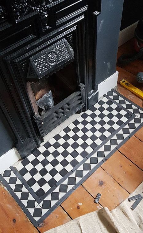 A black and white checkered tile floor next to a fireplace.