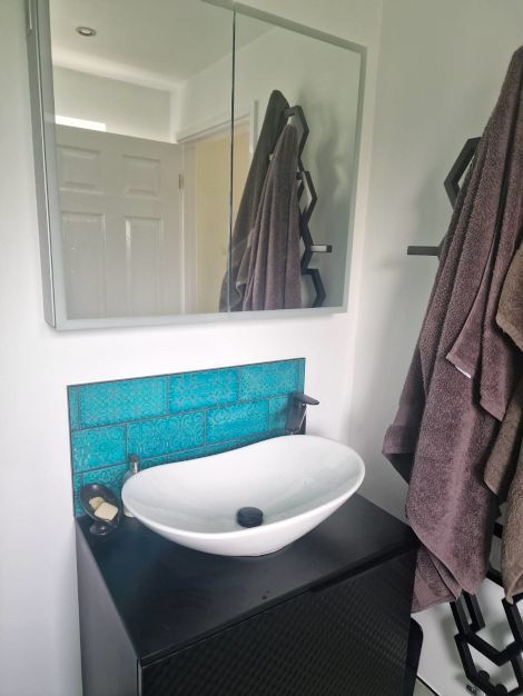 A lovely newly tiled bathroom and shower, completed with turquoise blue metro patterned and textured tiles in London.