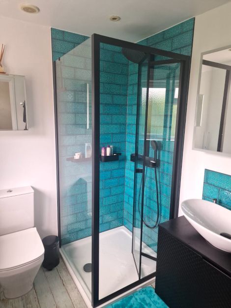 A lovely newly tiled bathroom and shower, completed with turquoise blue metro patterned and textured tiles in London.