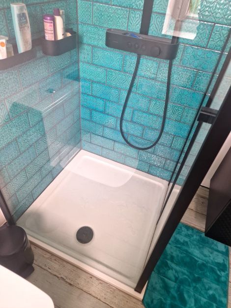 A lovely newly tiled bathroom and shower, completed with turquoise blue metro patterned and textured tiles in London.