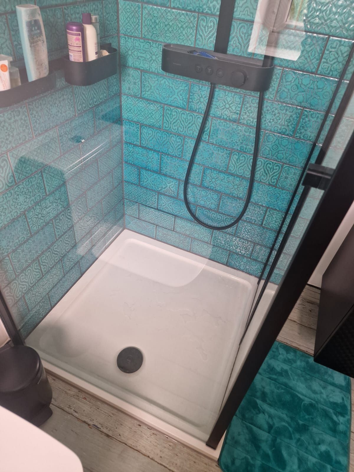 A finished shower renovation by Master Tiling in London. The shower has light blue metro tiles with soft patterns and textures.