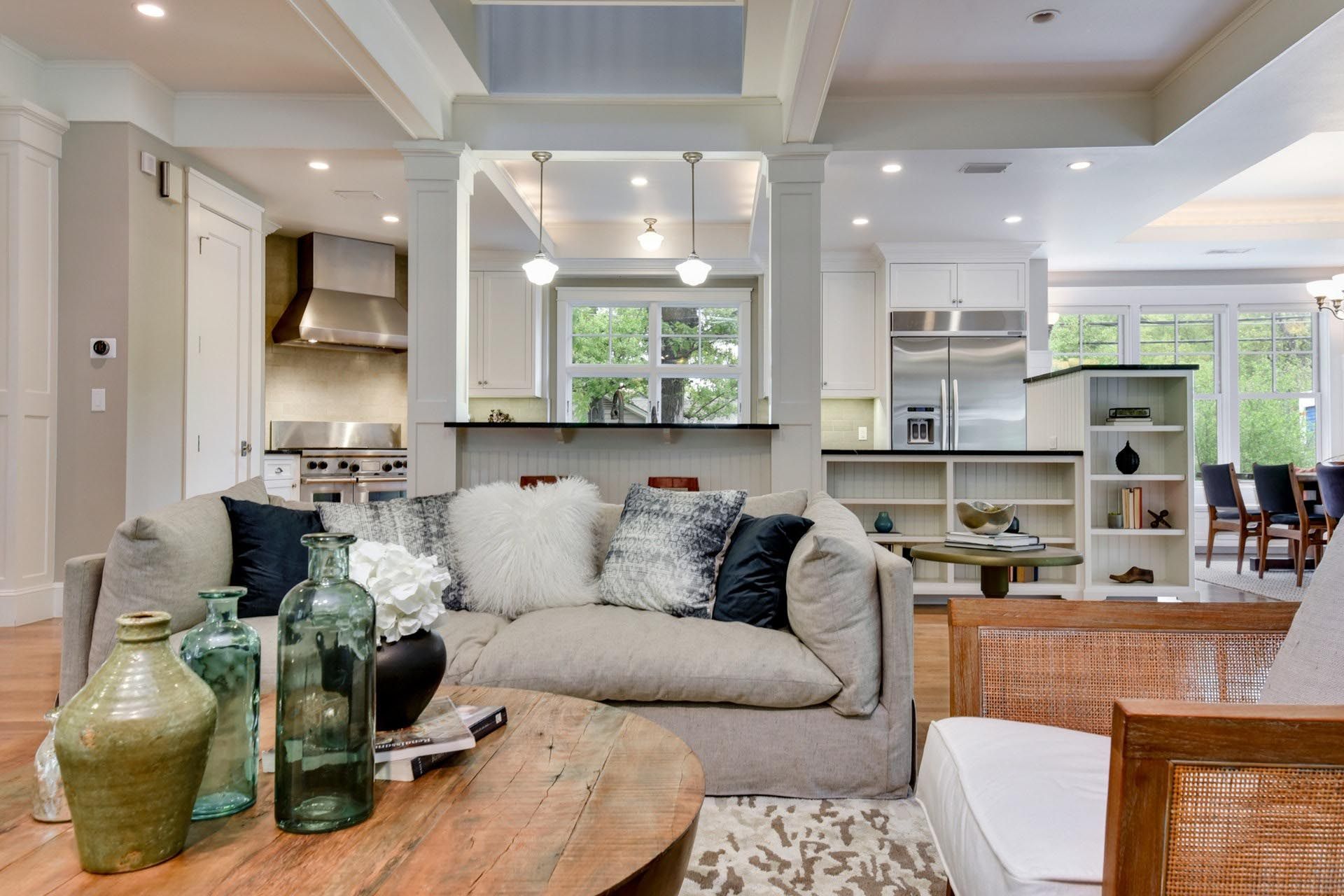Living room with open kitchen; sofa, coffee table, and exposed beams.