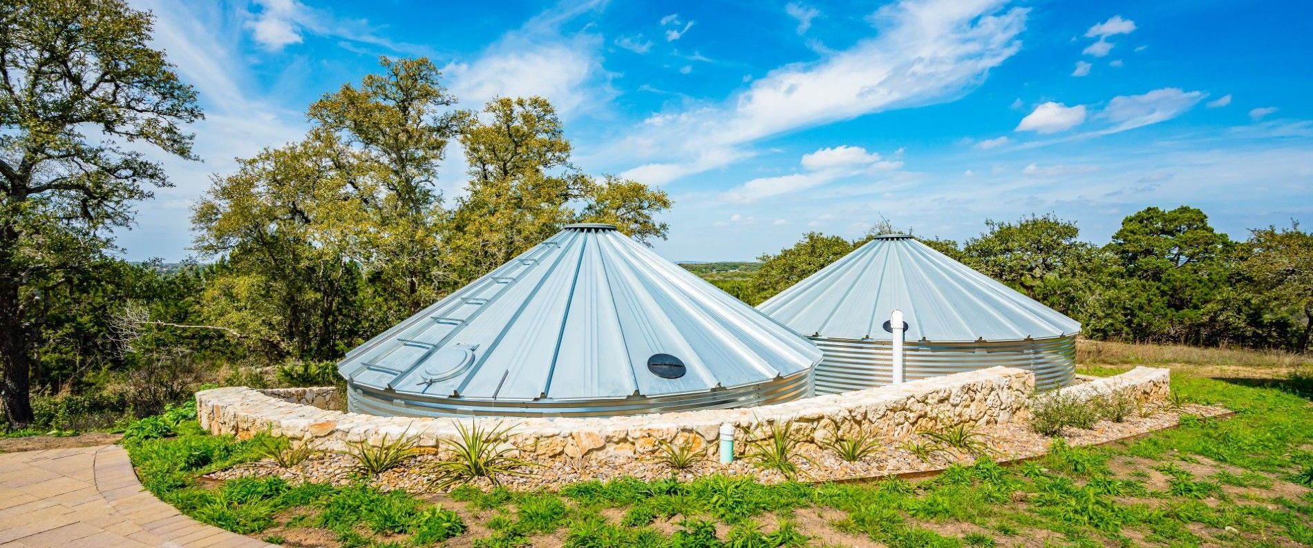 There are two yurts in the middle of a field.