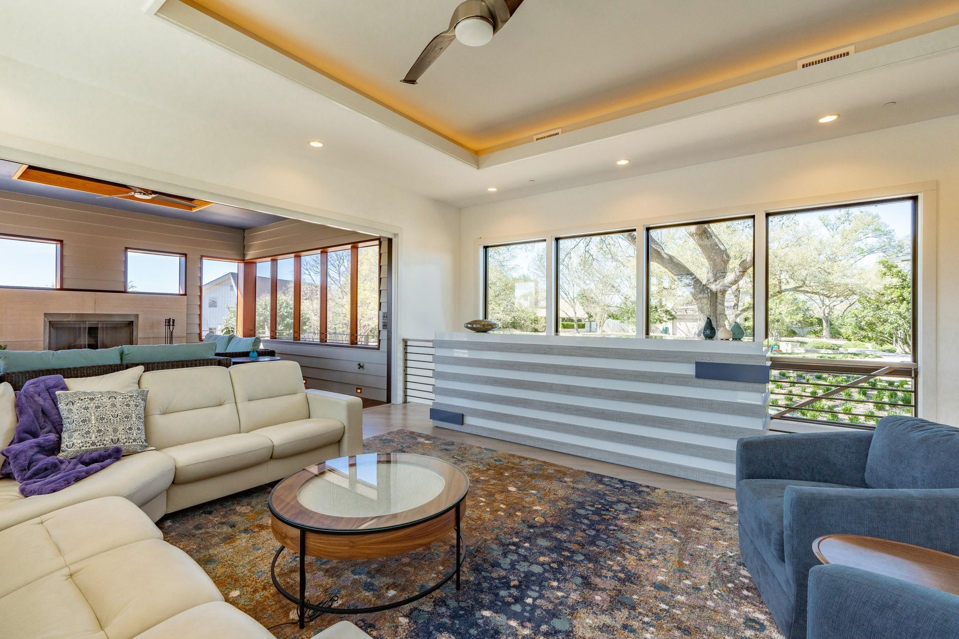 Living room with a sectional sofa, a rug, large windows, and an outdoor view.