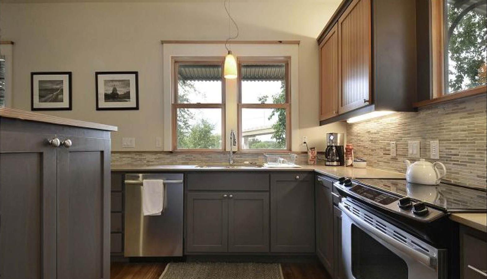 L-shaped kitchen with gray cabinets, stainless steel appliances, and a window above the sink.
