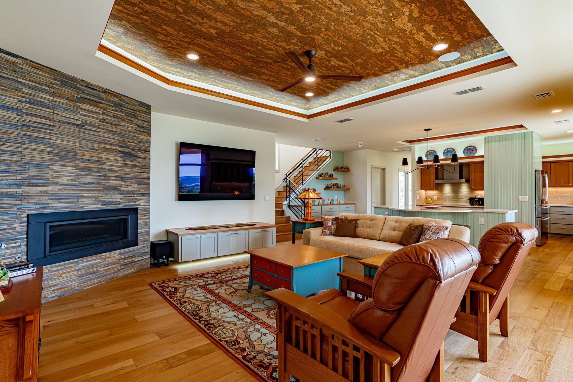 Living room with fireplace, TV, seating, and wood ceiling.