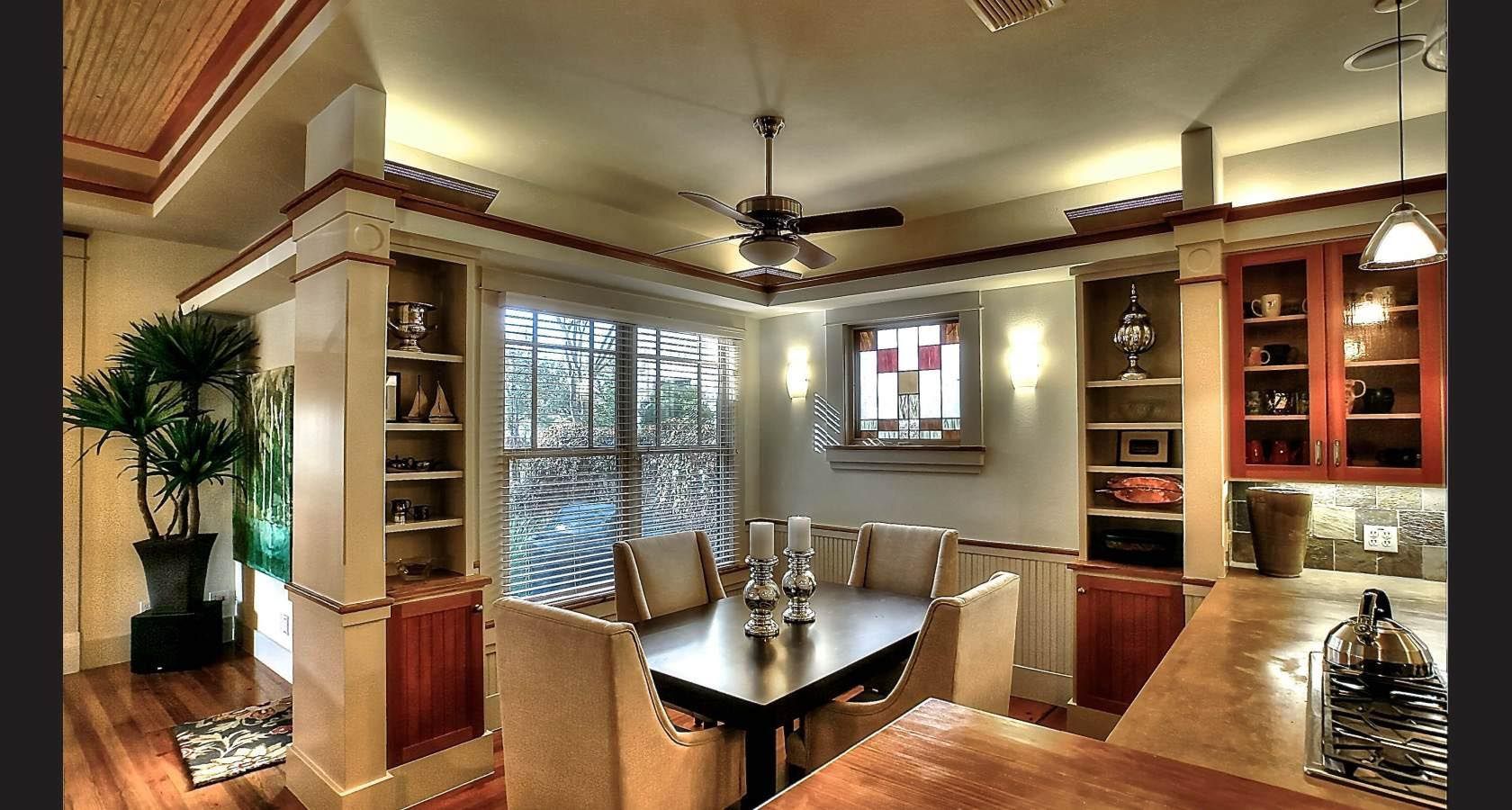 Dining room with table, chairs, built-in shelving, windows, and decorative ceiling details.