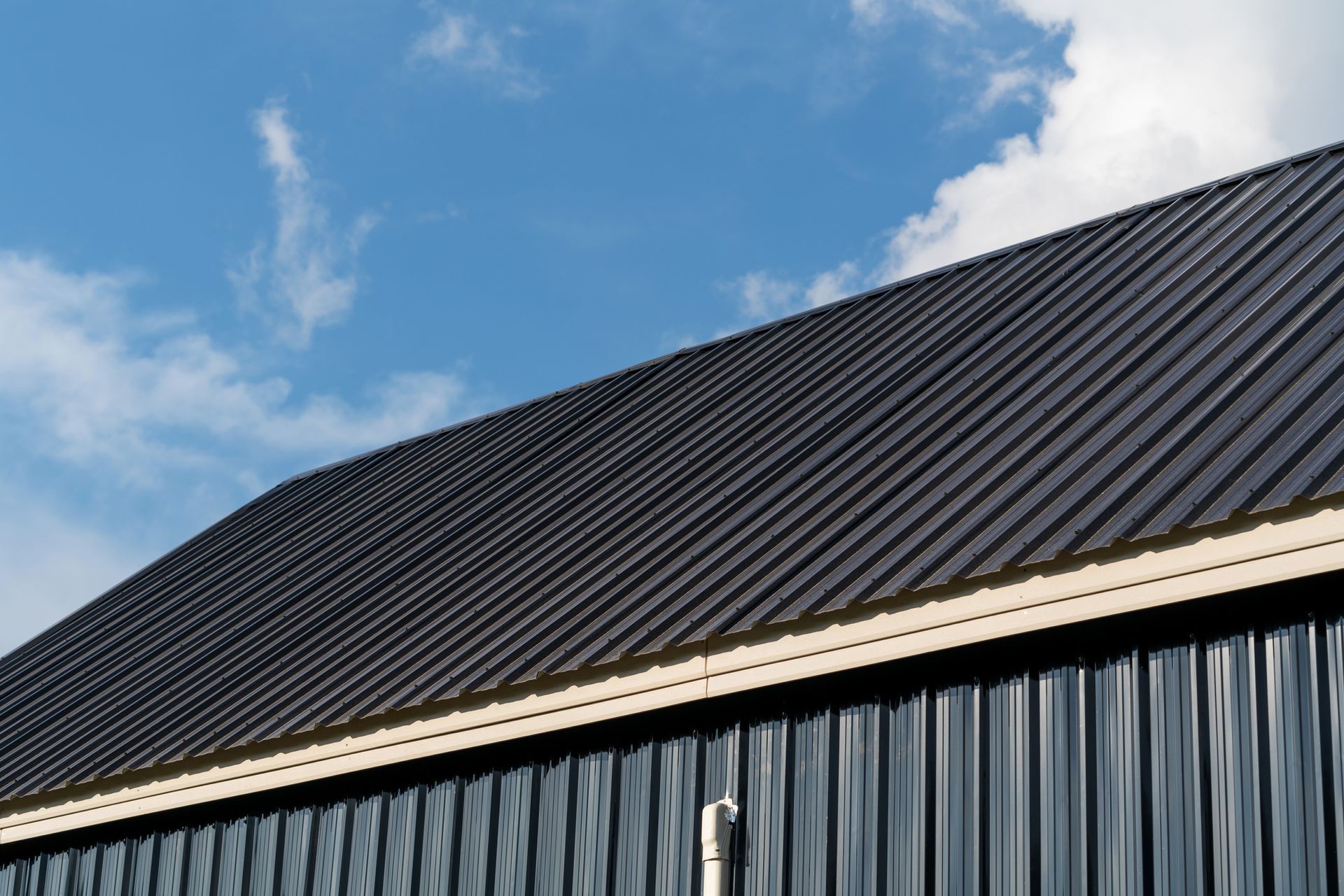 The roof of a building with a blue sky in the background.