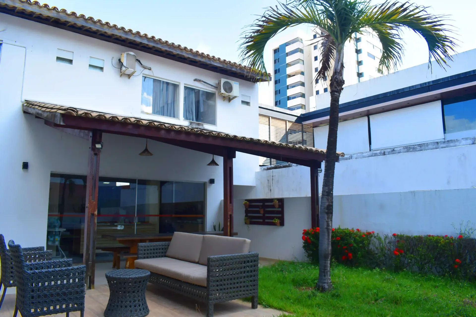 Uma casa branca com uma área de pátio com um sofá e cadeiras-Alto da Praia Hotel