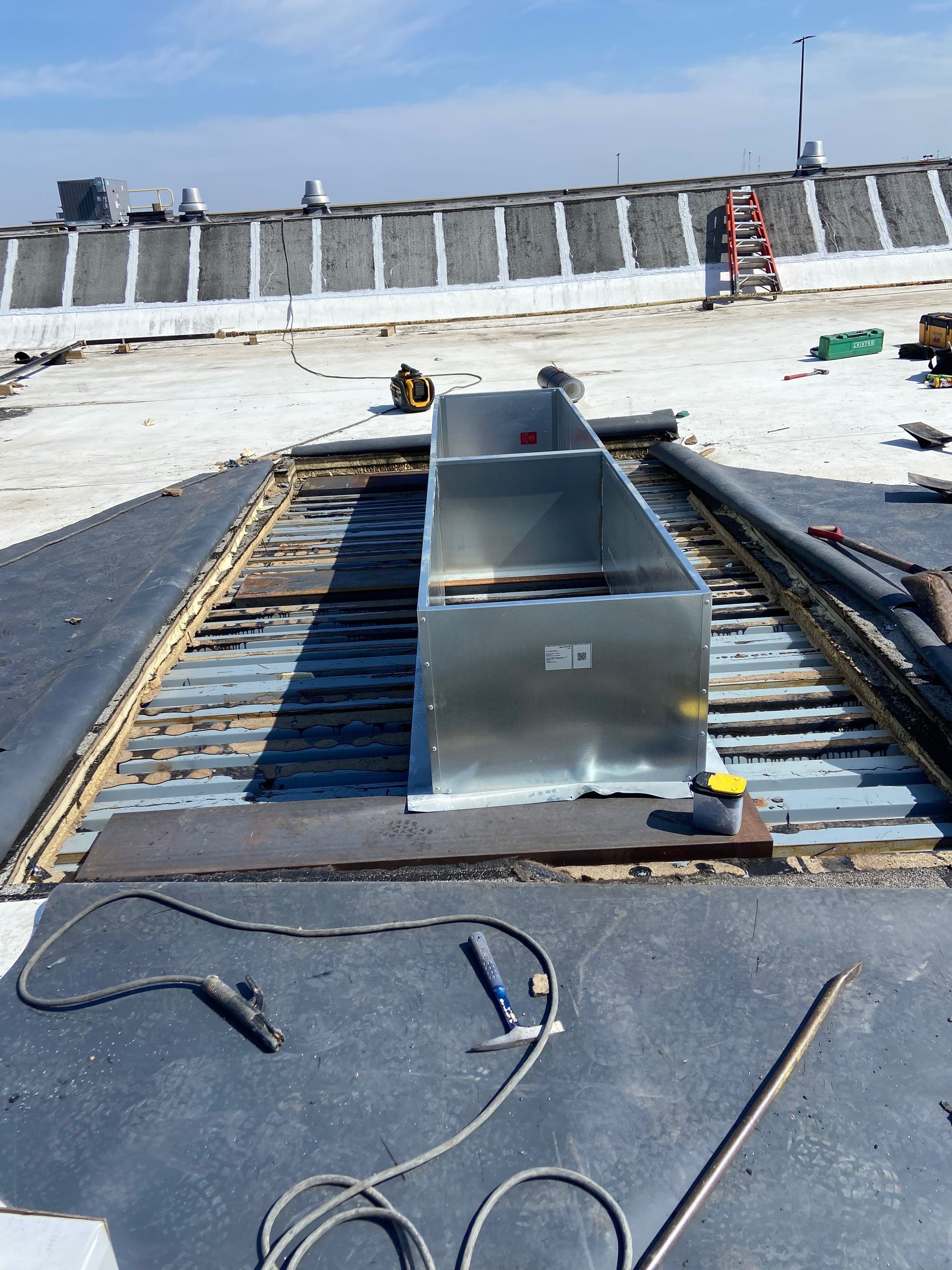 A man is working on a roof with a drill.