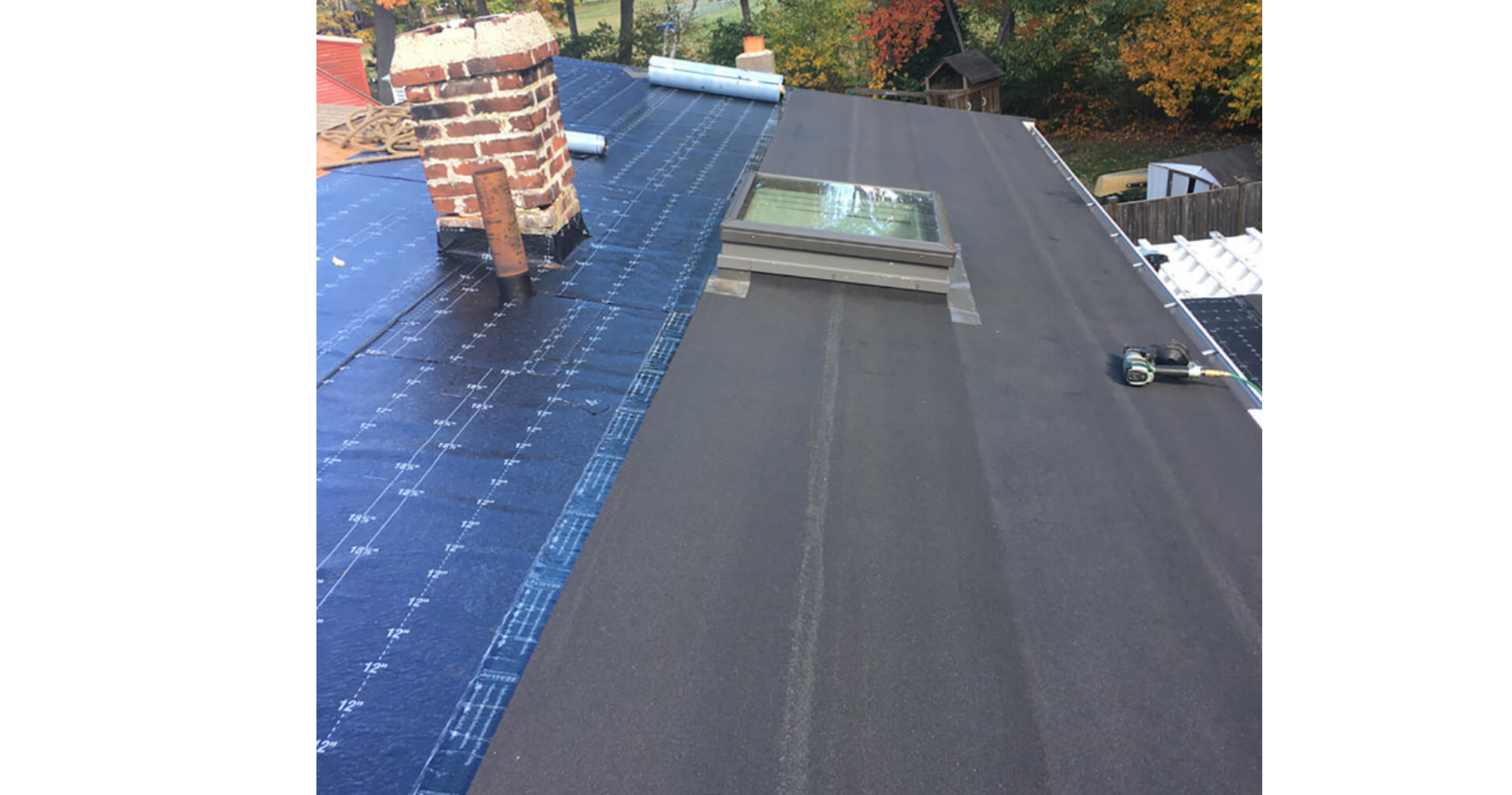 A roof with a skylight and a chimney on it.