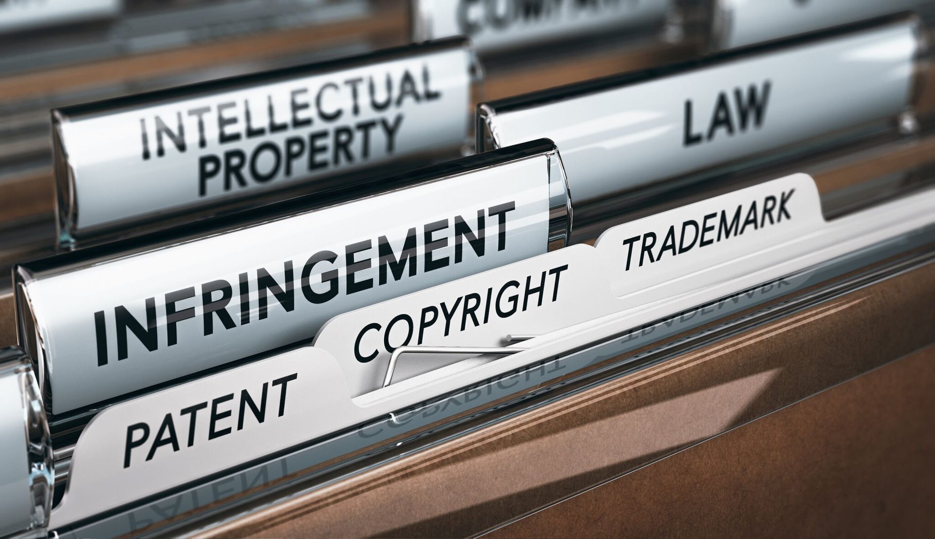 File folders labeled intellectual property law, infringement, patent, copyright, and trademark in an office file holder