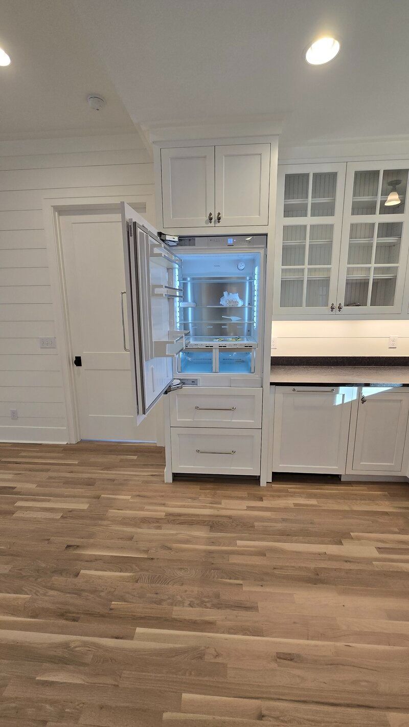 White kitchen with an open refrigerator.