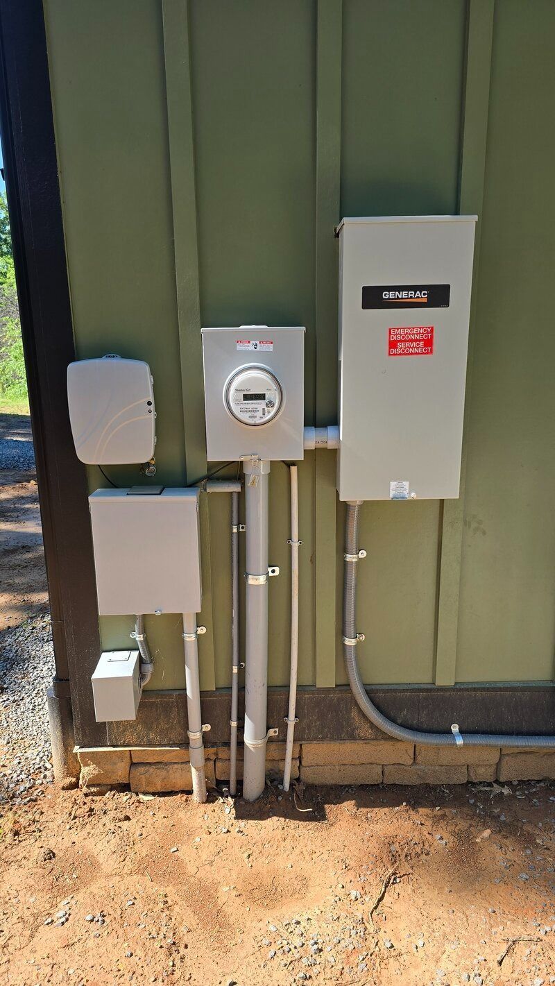 Electrical meter box and panel on a green building with conduit and wiring visible.