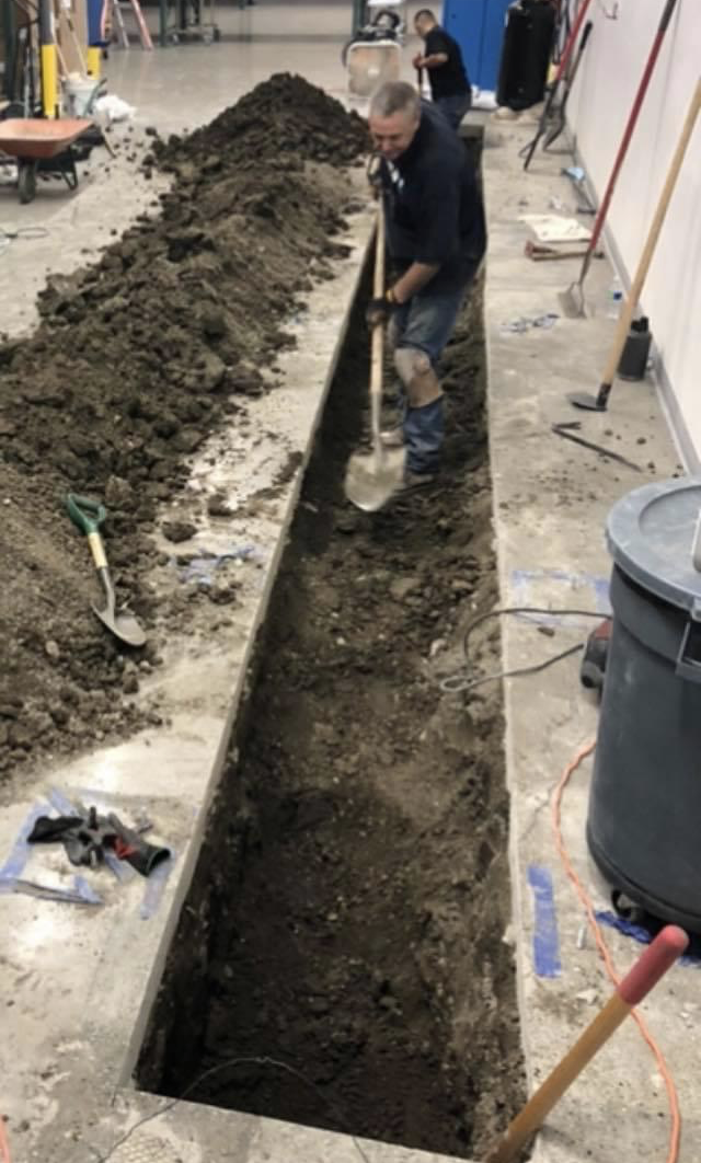 men digging a trench with shovels for plumbing