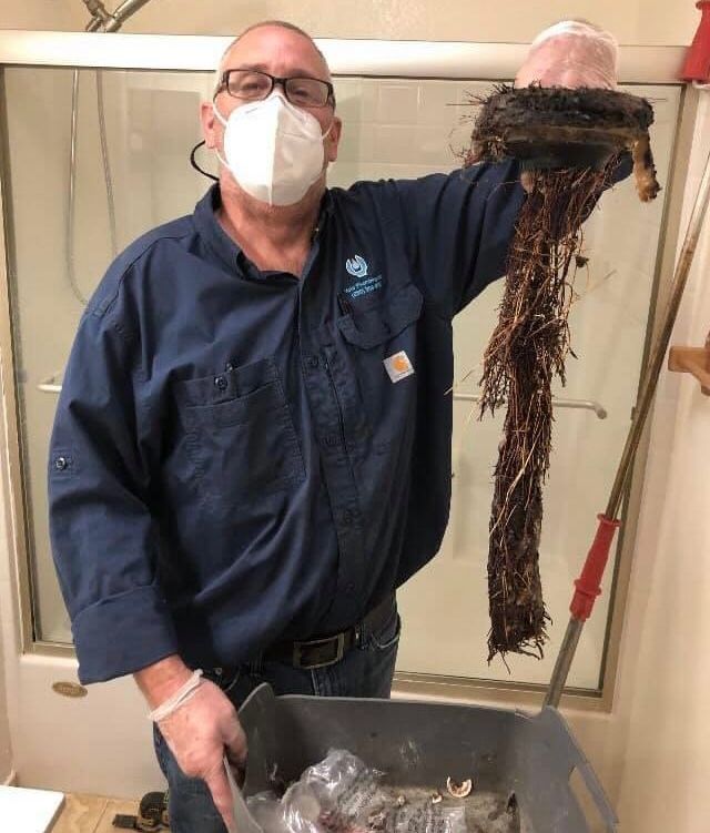 Joe Weins holding large accumulation of gunk from sink
