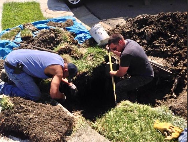 2 men digging a ditch for plumbing pipeline