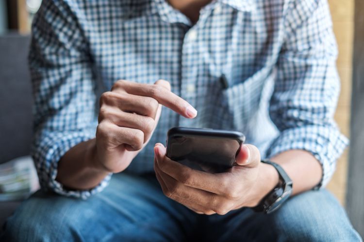 Un homme qui regarde son téléphone cellulaire.