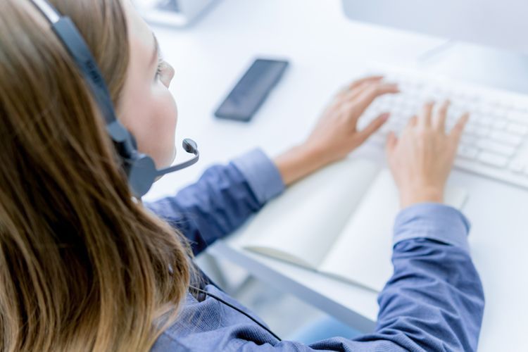 Une femme qui travaille au service à la clientèle devant son ordinateur.